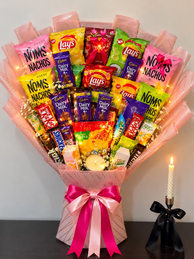 Blush-pink snack bouquet filled with chocolates, chips, nachos and drinks, decorated with satin ribbons, flowers and warm fairy lights.