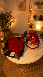  red rose bouquet and kit kat gift basket on a marble table 
