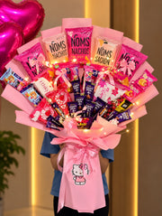 Pink chocolate and snack bouquet with Noms Nachos, Dairy Milk, KitKat, satin bows, fairy lights and a Hello Kitty decoration.