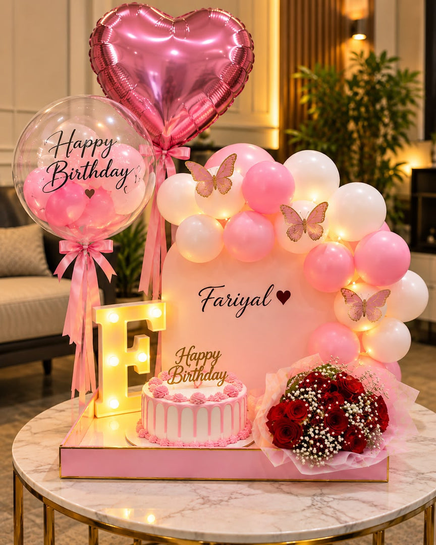 Butterfly Reverie birthday setup with pink balloons, butterfly decorations, cake and red rose bouquet