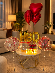Love Beyond Forever romantic gift setup with red heart balloons, roses, cake and luxury celebration decorations