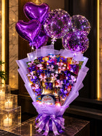 Load image into Gallery viewer, Lavender-wrapped chocolate and snack bouquet with KitKat, Snickers, Danisa cookies, purple bows, heart balloons and illuminated confetti balloons.