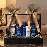 Load image into Gallery viewer, Men's grooming gift hamper with Nivea, L'Oréal Men Expert and Sebamed skincare products in a black wooden crate with golden ribbons.