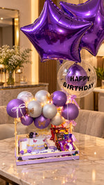 Load image into Gallery viewer, Violet Bloom luxury purple birthday gift setup with star balloons, cake, chocolates, and illuminated decorations