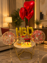 Love Beyond Forever romantic gift setup with red heart balloons, roses, cake and luxury celebration decorations