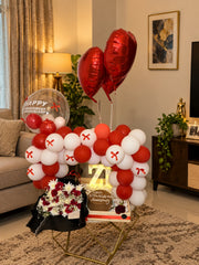 Scarlet Promise luxury anniversary gift arrangement with red roses, balloon décor and celebration cake setup