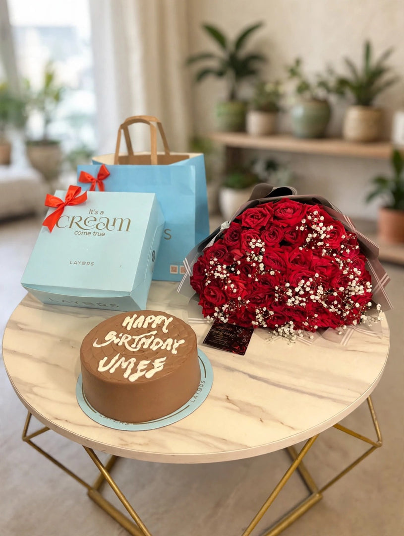 Red rose bouquet with chocolate birthday cake and blue gift bag