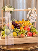 Load image into Gallery viewer, Luxury get well soon fruit basket with bananas, apples, grapes, oranges, white roses, ivory ribbons, and a wooden gift crate.