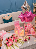 Load image into Gallery viewer, Pink birthday gift set with a rose and white flower bouquet, cake in a lighted clear box, perfume basket, floral garlands and pink and silver star balloons.