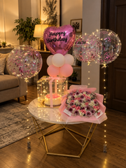 Pink Fantasy Affair birthday setup with pink balloons, cake, floral bouquet and luxury celebration decorations