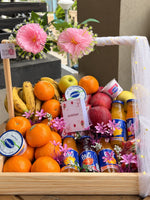 Load image into Gallery viewer, Wooden get well soon hamper filled with bananas, oranges, apples, bottled fruit drinks, and yoghurt cups, decorated with pink flowers and white mesh.