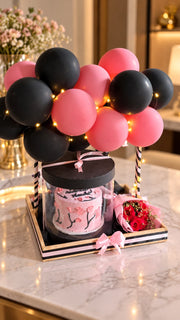 Rose Noir Elegance gift arrangement with red roses, pink black balloons, cake and luxury celebration box