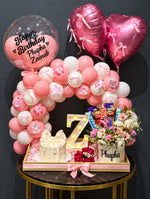 Load image into Gallery viewer, Pink and white birthday balloon arrangement with heart-shaped balloons, chocolates, flowers and a personalized display.