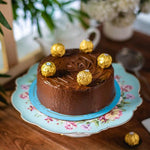 Load image into Gallery viewer, Luxury chocolate cake decorated with Ferrero Rocher chocolates on a floral serving plate