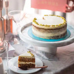 Load image into Gallery viewer, Layered nut cake with white cream frosting, chopped nut decoration and a slice showing its layered filling.