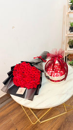 Load image into Gallery viewer, red rose bouquet and a kitkat wrapped gift basketon a white table 