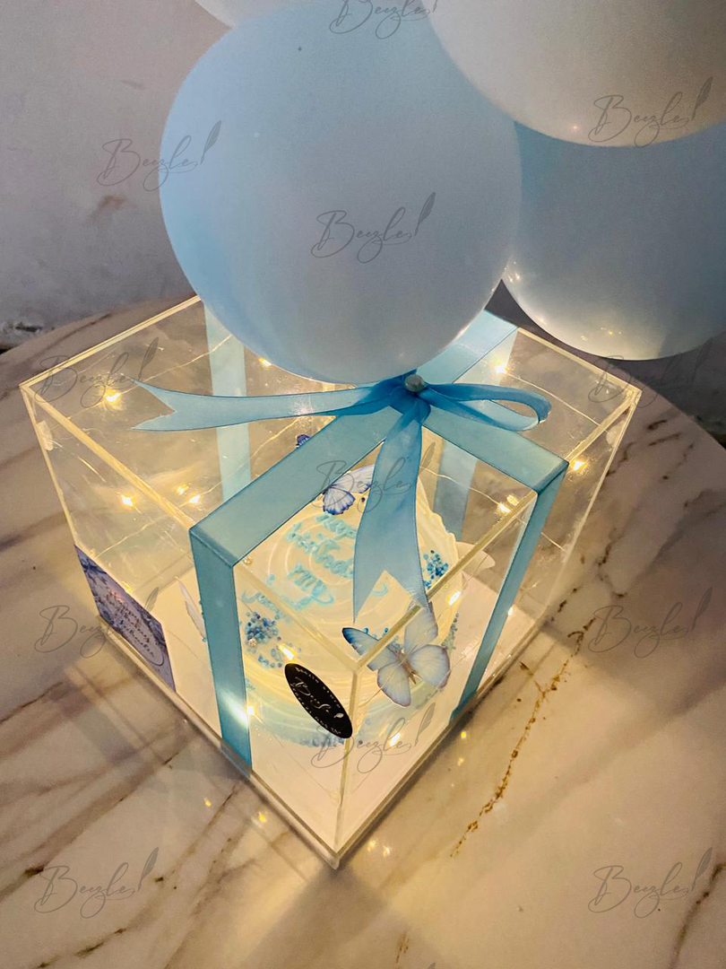 Illuminated birthday cake gift box with blue ribbon and butterfly decoration