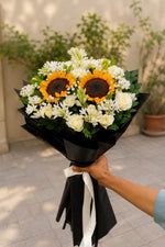 Load image into Gallery viewer, "Sunlit Ivory Bouquet - sunflowers and white roses wrapped in black paper with white ribbon"