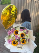 Load image into Gallery viewer, Golden Meadow bouquet with fresh sunflowers, white chrysanthemums, purple flowers, baby's breath, and a gold heart balloon
