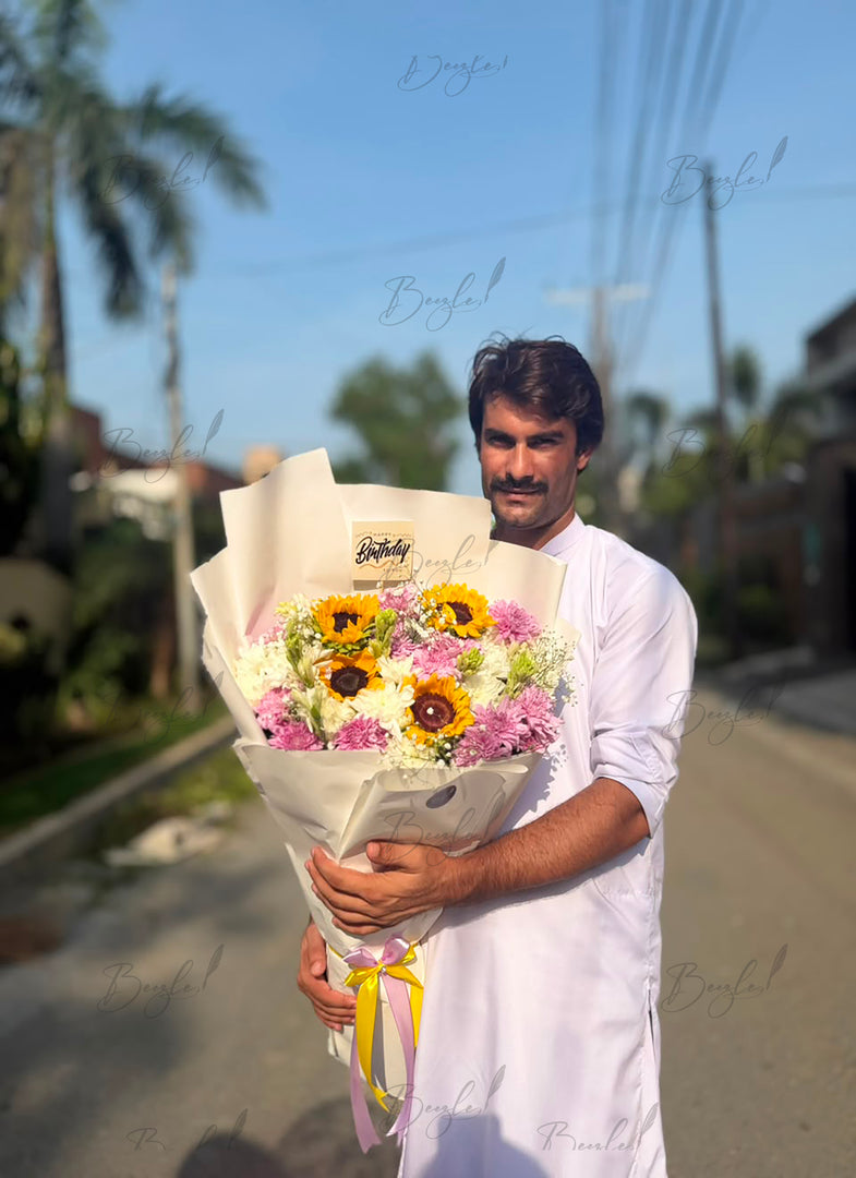 Fresh sunflower and mixed flower bouquet wrapped in white paper with a gold balloon for birthday celebrations and special occasions