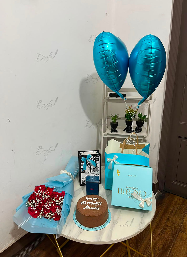 Azure Prestige premium birthday gift hamper with red rose bouquet, chocolate cake, perfume, luxury gift box, shopping bags, and blue helium balloons