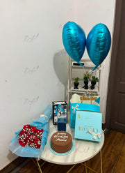 Azure Prestige premium birthday gift hamper with red rose bouquet, chocolate cake, perfume, luxury gift box, shopping bags, and blue helium balloons
