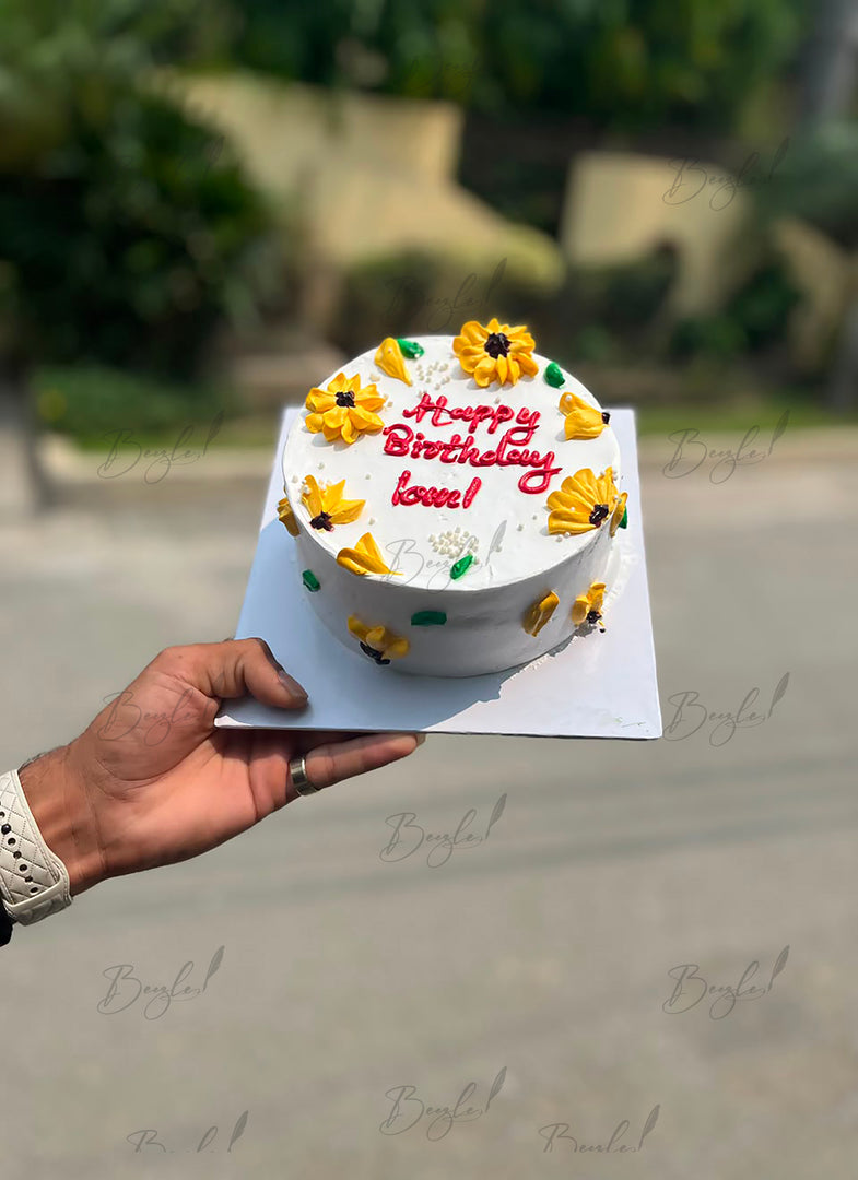 Cream birthday cake with yellow floral decorations