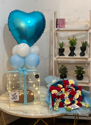 Premium flower and balloon hamper featuring colorful roses with a glowing surprise box.