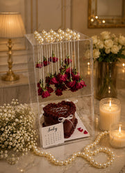 Rose Elegance Memory Box with floating red roses, chocolate cake, pearl decorations, and luxury acrylic gift display.