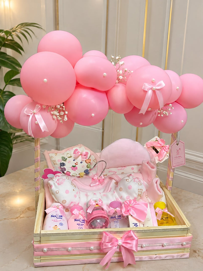 Pink Blossom Cradle luxury baby hamper with pink balloons, baby essentials, and decorative ribbon tray.