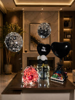 Load image into Gallery viewer, Midnight Royale luxury birthday setup with black balloons, glowing gift box, money bouquet, and snack hamper.