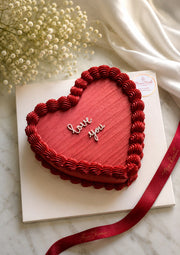 Yours Truly heart-shaped red cake with Love You message and red ribbon