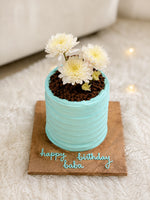 Load image into Gallery viewer, Garden Grace Cake featuring pastel blue buttercream, white flowers, and personalized birthday message decoration on a wooden cake board.