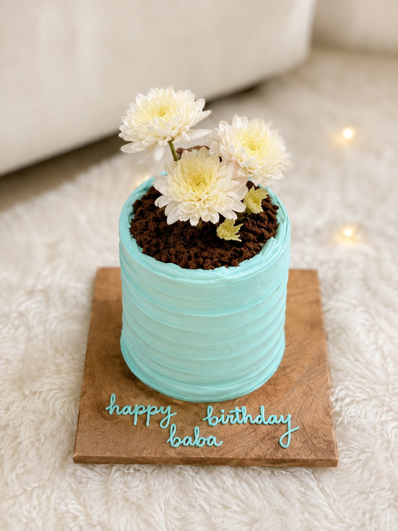 Garden Grace Cake featuring pastel blue buttercream, white flowers, and personalized birthday message decoration on a wooden cake board.