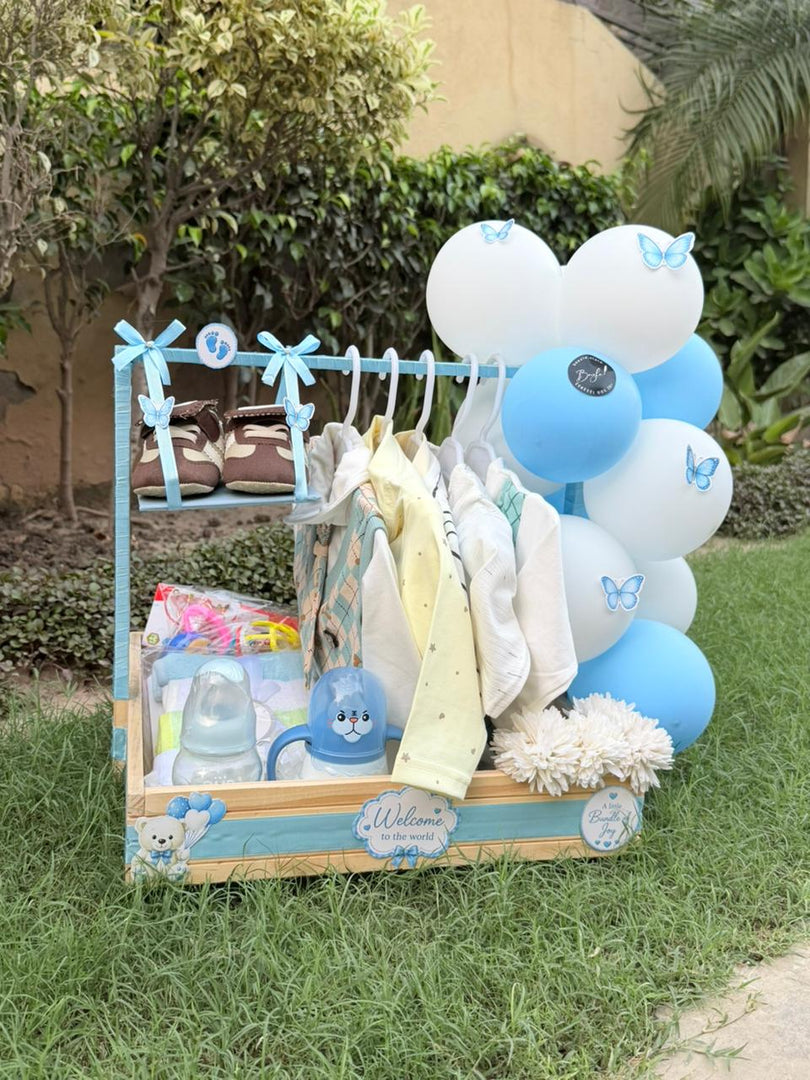 Newborn welcome gift set with baby clothes, feeding bottle, mug and decorative balloons 