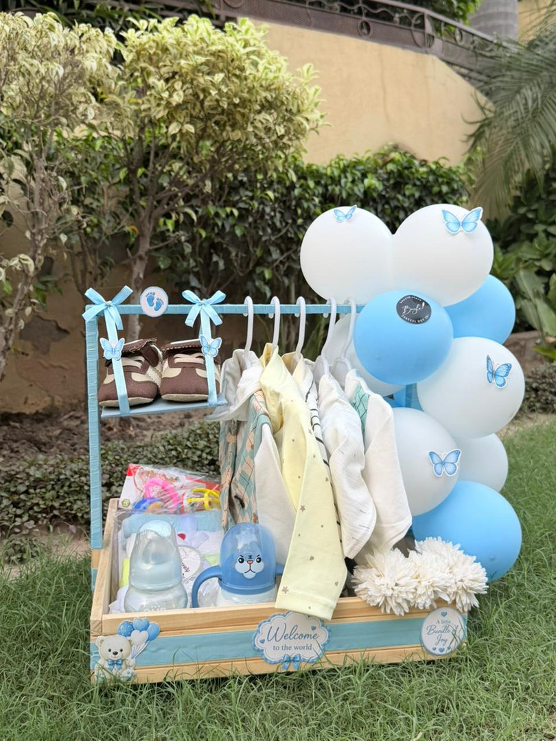 Bluebell Beginnings newborn gift hamper with baby clothes, tiny shoes, feeding bottle and blue white balloons