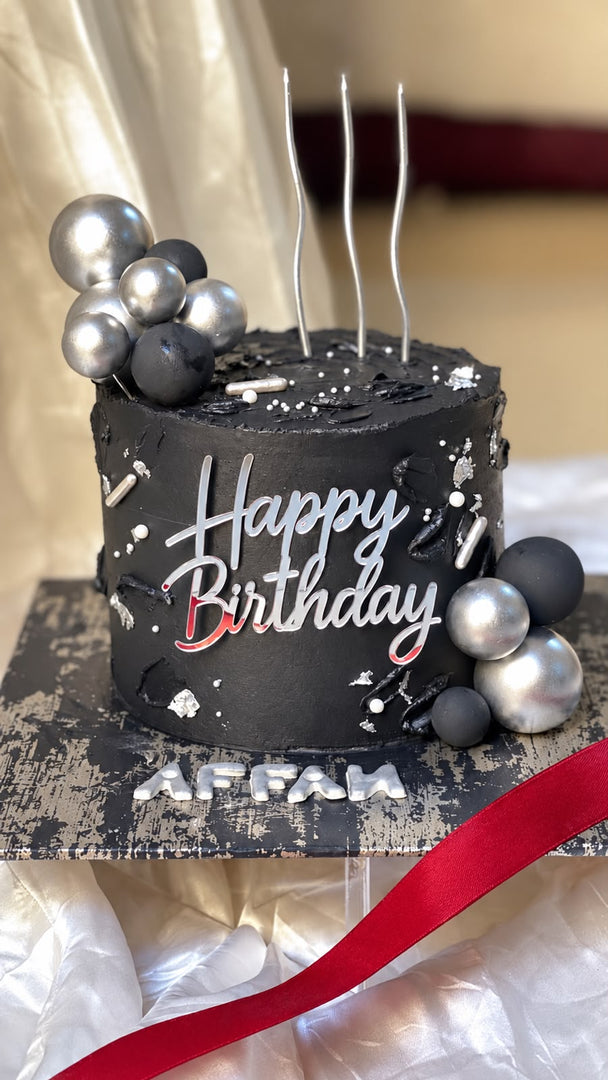 Silver Noir black and silver birthday cake with metallic balloons