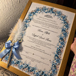Load image into Gallery viewer, Personalised blue floral Nikah certificate in a gold frame with Arabic calligraphy, pearl embellishments, and a matching feather Nikah pen.