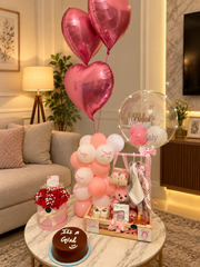 Newborn baby girl gift hamper with pink balloons, baby clothes, teddy bear and welcome baby balloon