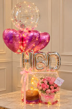 Load image into Gallery viewer, Rosy Birthday Glow with pink roses, heart balloons and illuminated gift box