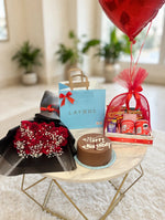 Load image into Gallery viewer, Red rose bouquet with white filler flowers beside a Happy Birthday cake and a snack hamper wrapped in red mesh.
