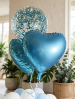 Load image into Gallery viewer, Clear balloons filled with blue confetti beside metallic teal heart-shaped balloons with warm fairy lights.
