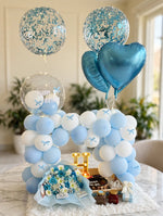 Load image into Gallery viewer, Blue and white birthday gift display with a balloon arch, flower bouquet, cake, illuminated letter H, treat jars, and wrapped gift.