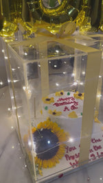 Load and play video in Gallery viewer, Premium birthday surprise featuring a glowing acrylic gift box, cake, gold foil balloons, LED fairy lights, and customized birthday balloon arrangement.